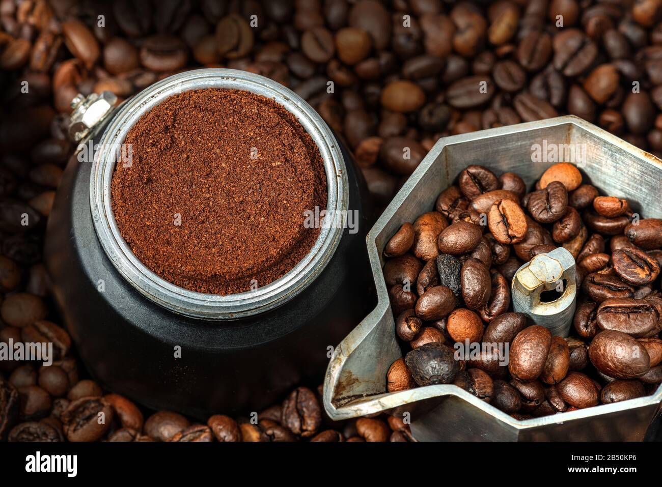 Primo piano di una macchina per il caffè all'aperto con caffè macinato nel filtro in metallo, su molti chicchi di caffè tostati Foto Stock