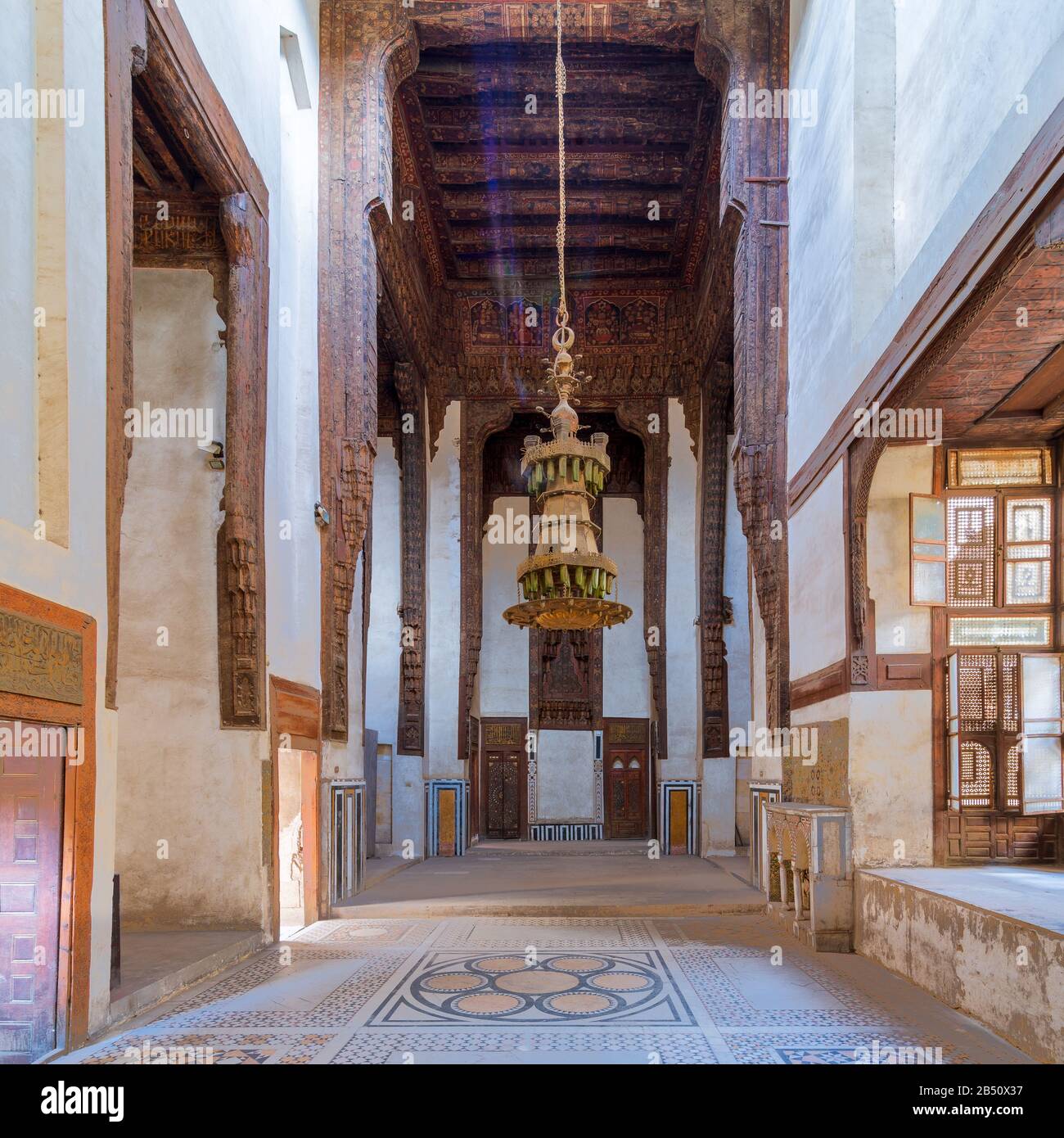 Hall all'epoca ottomana storica casa di Zeinab Khatoun con soffitto in legno dipinto, pavimento in marmo decorato con motivi geometrici colorati, e grande lampadario, il Cairo medievale, Egitto Foto Stock