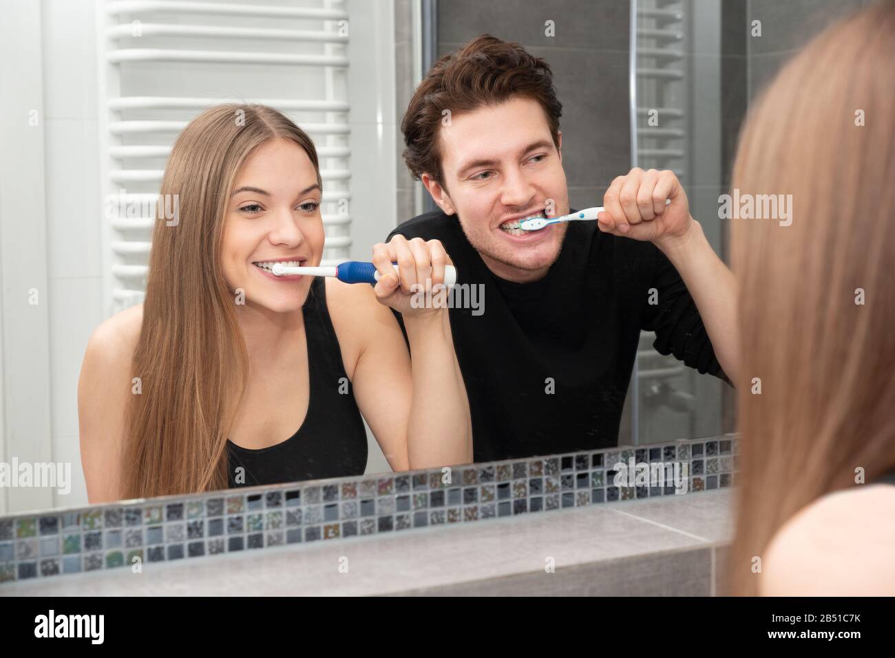 Coppia denti spazzolanti in bagno. Concetto di salute dentale Foto Stock