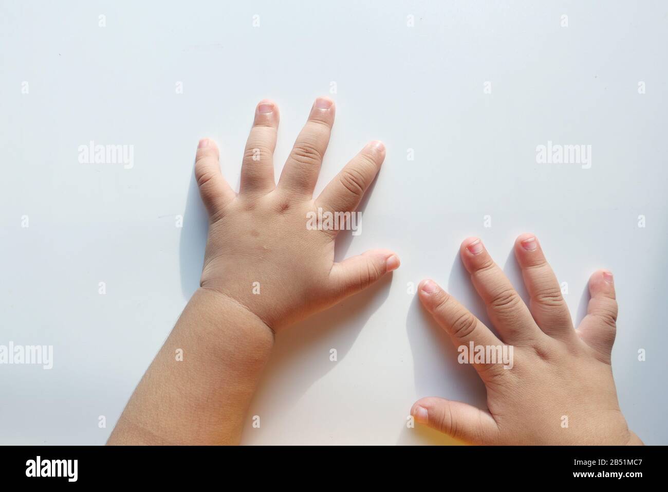 Primo piano di bambino mano su sfondo bianco Foto Stock