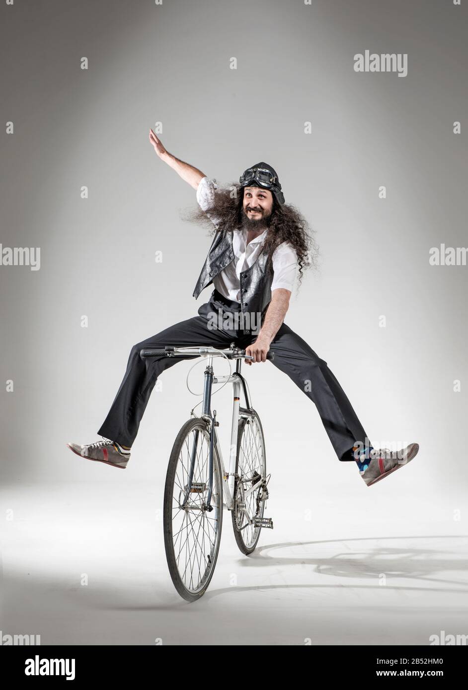 Ritratto di un geek skinny a cavallo di una bicicletta Foto Stock