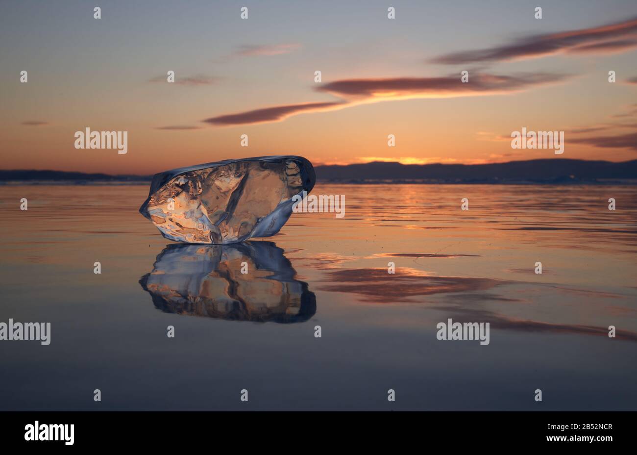 Un pezzo di ghiaccio si riflette in Baikal al tramonto Foto Stock