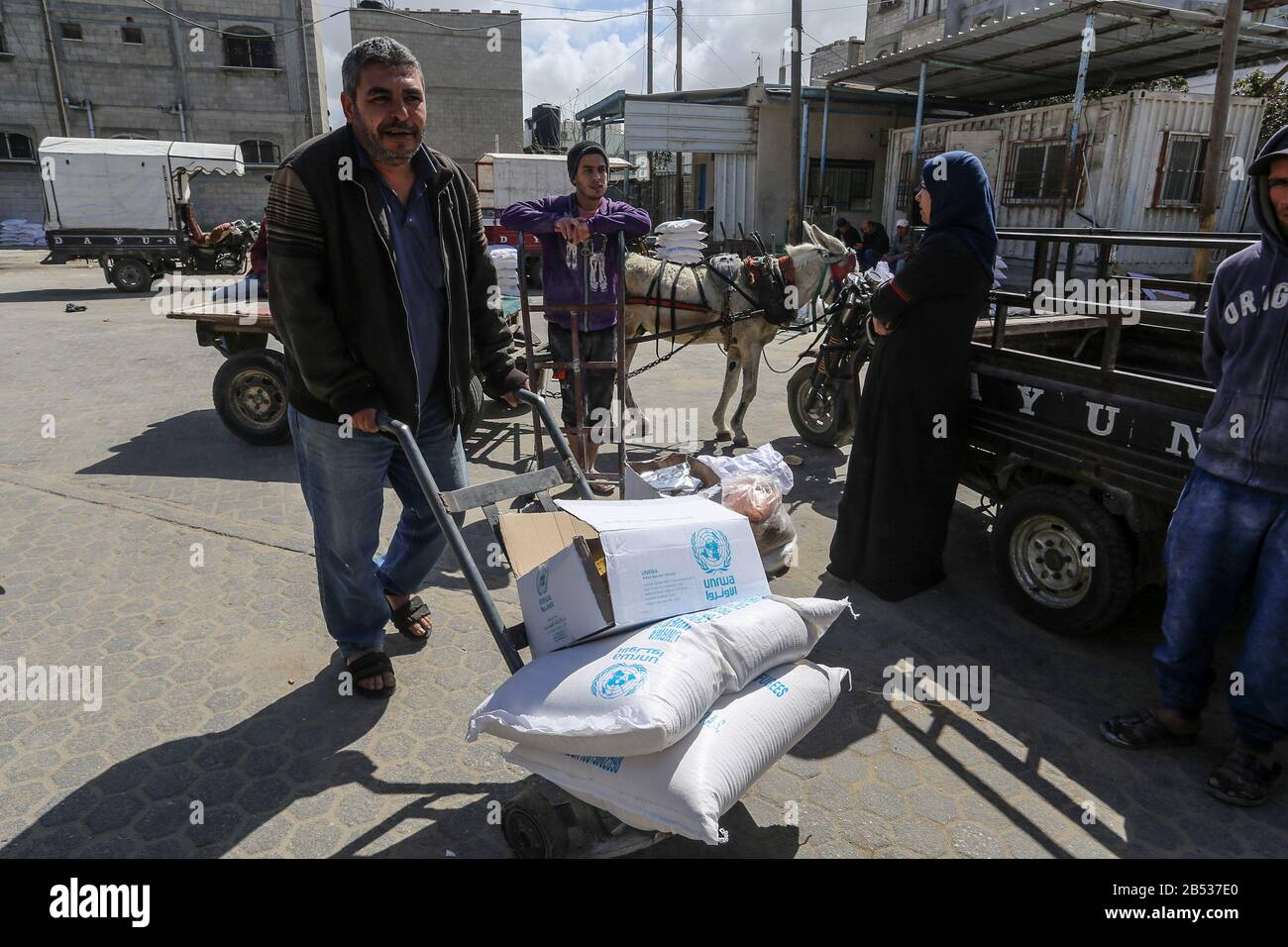 I palestinesi ricevono il loro aiuto alimentare mensile presso un centro di distribuzione delle Nazioni Unite (UNRWA) nella città meridionale di Rafah, nella striscia di Gaza, il 7 marzo 2020 Foto Stock