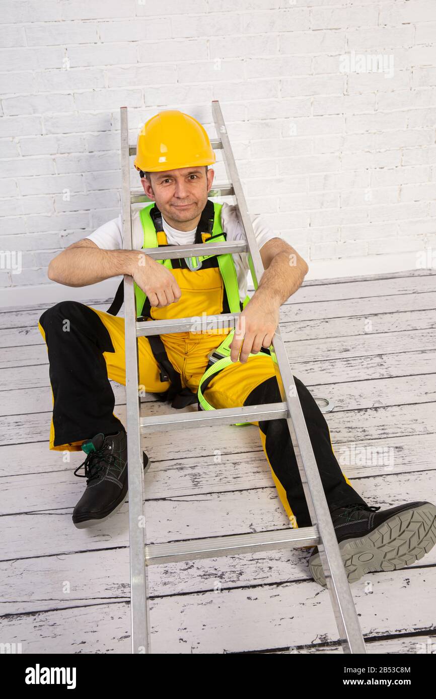 Un pittore professionista compatto e pronto a lavorare in qualsiasi momento. Indossa i tipici indumenti protettivi utilizzati nel cantiere. Foto Stock