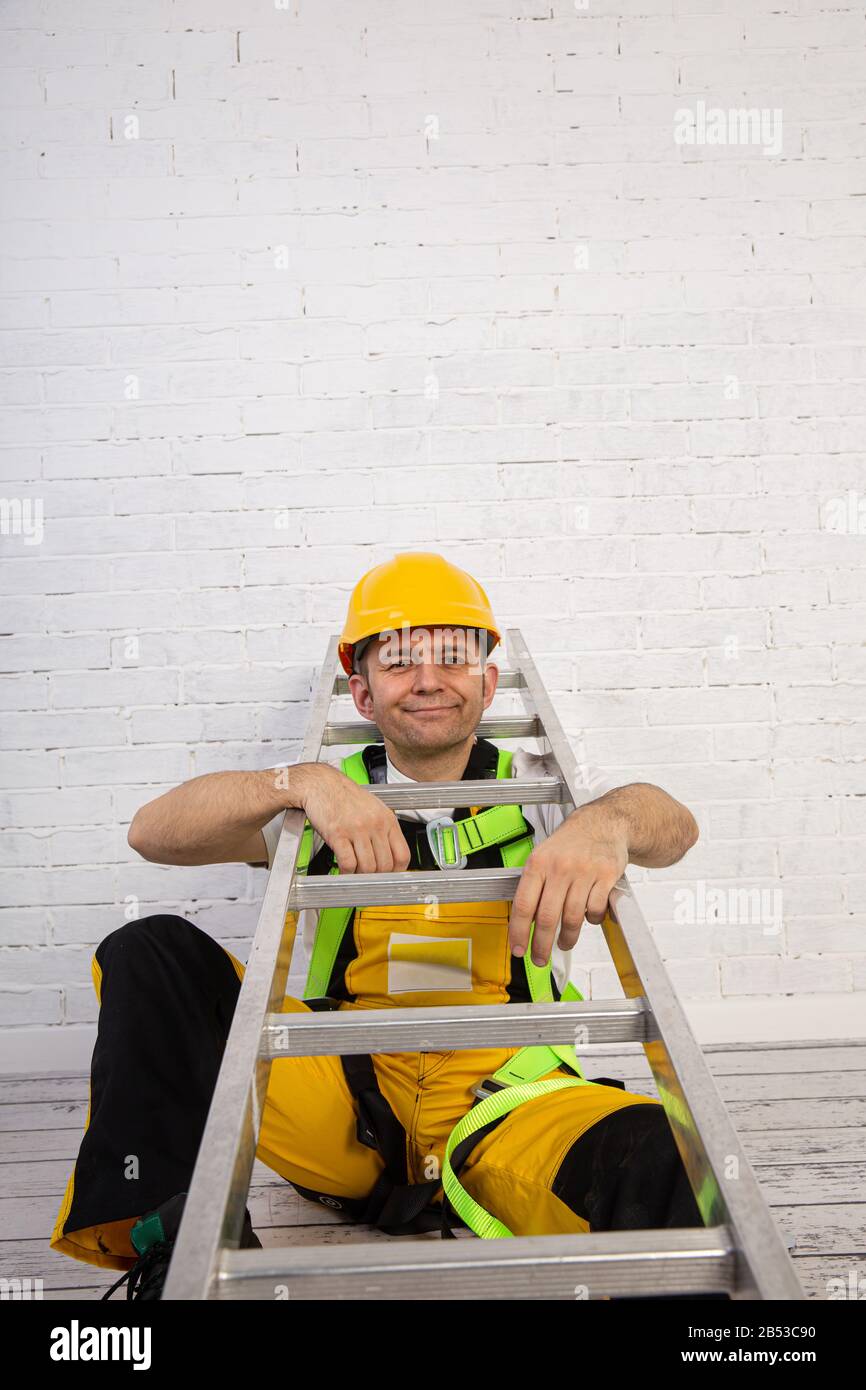 Un pittore professionista compatto e pronto a lavorare in qualsiasi momento. Indossa i tipici indumenti protettivi utilizzati nel cantiere. Foto Stock