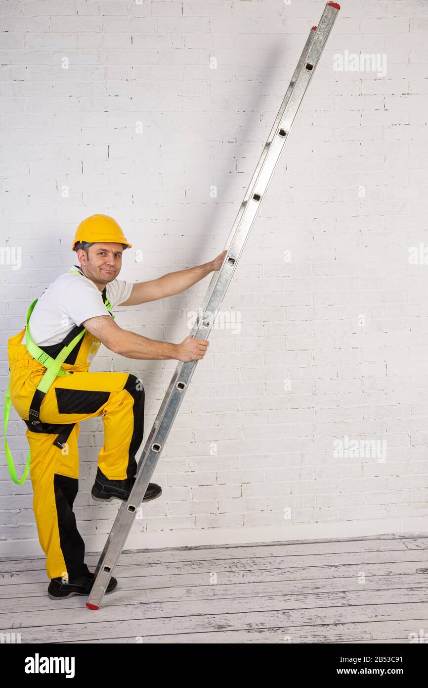 Un pittore professionista compatto e pronto a lavorare in qualsiasi momento. Indossa i tipici indumenti protettivi utilizzati nel cantiere. Foto Stock