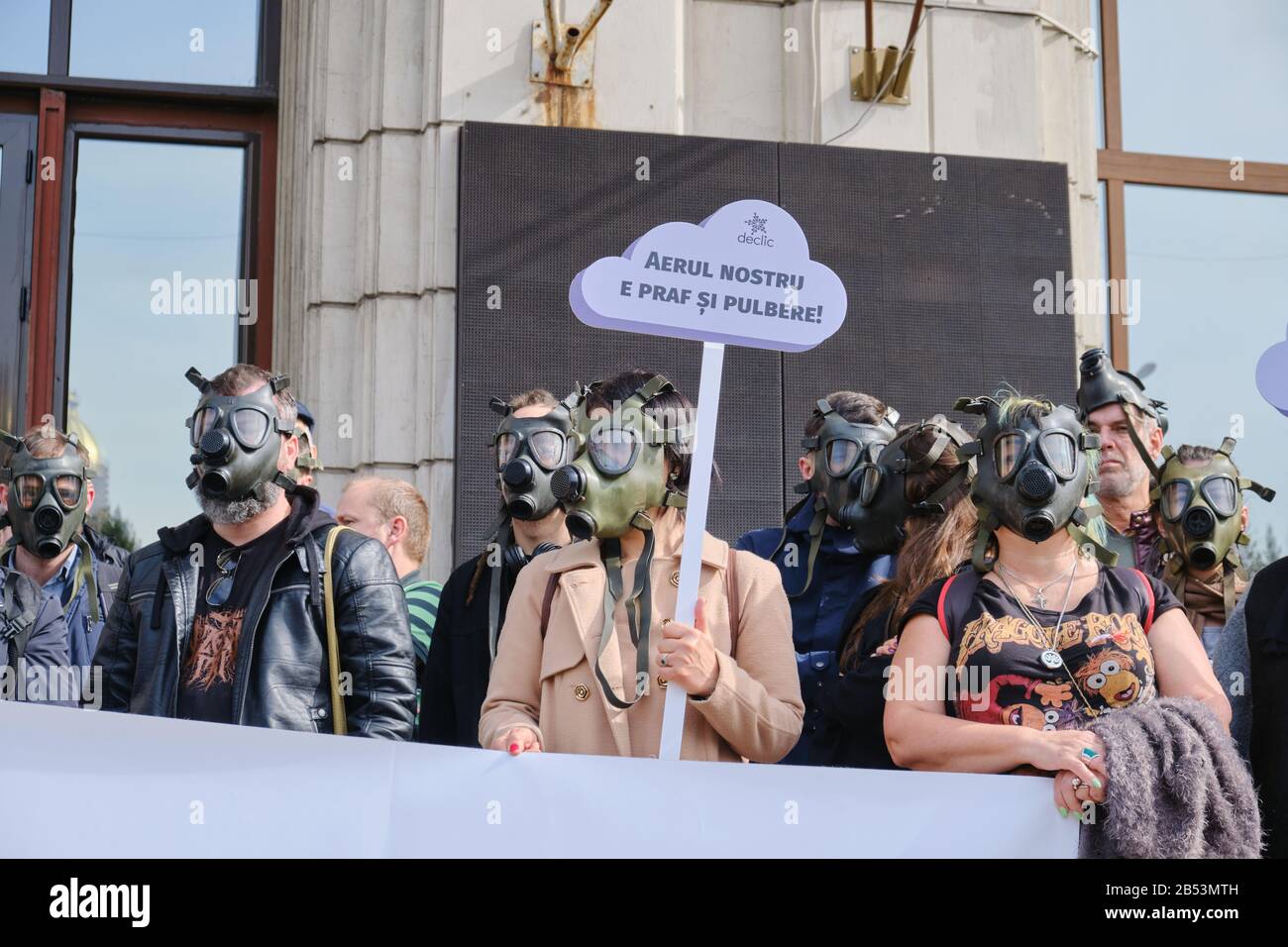 Bucarest, Romania - 4 marzo 2020: I manifestanti con maschere a gas hanno un segnale che dice Che La Nostra aria è polvere e paludi, in risposta all'inquinamento atmosferico estremo in Ro Foto Stock
