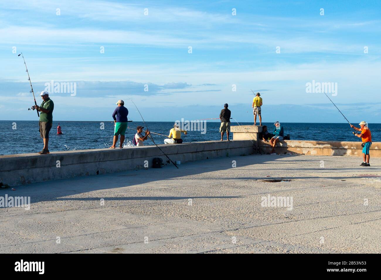 Numerosi pescatori cubani vicino alla passeggiata di Malecon nel tardo pomeriggio. L'Avana, Cuba. Foto Stock