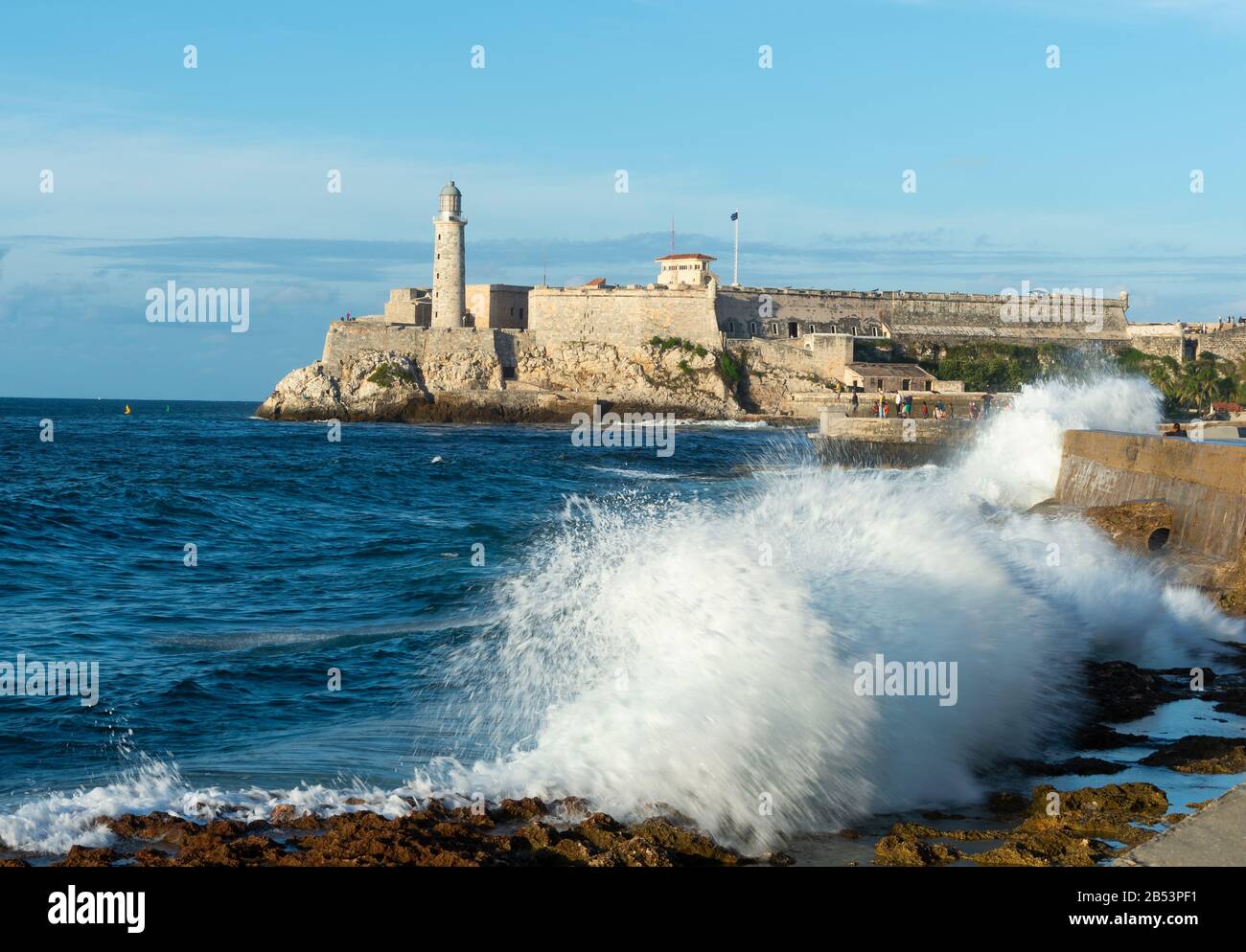 Faro Castillo del Morro a l'Avana, Cuba è un faro costruito nel 1845 a guardia del porto di la Habana. Onde che colpiscono El Malecón spianata. Foto Stock