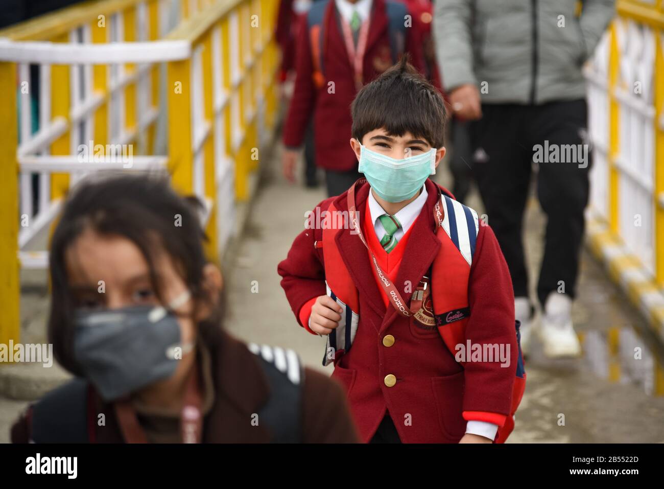 Uno studente del Kashmir che indossa una maschera facciale come misura protettiva contro il virus della corona.Autorità in Kashmir ordine chiusura di tutte le scuole primarie dal 9 marzo in quattro distretti, compreso Srinagar, nella valle fino a ulteriore avviso. Il numero totale di casi mortali di virus corona in India raggiunge 34 dopo 2 casi da Ladakh e 1 caso da Tamil Nadu testato positivo. Foto Stock