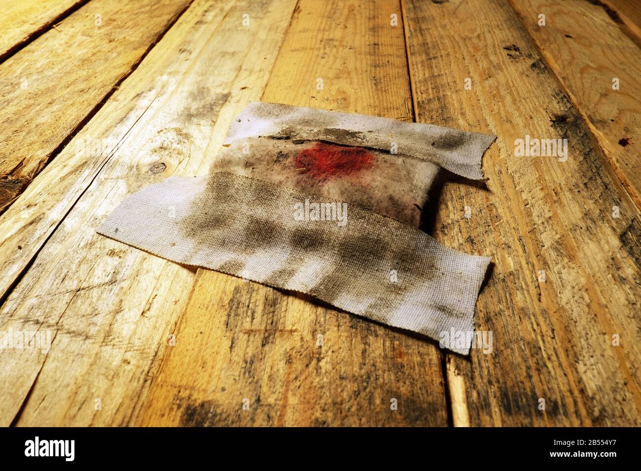 Una fasciatura sporca su un pavimento in legno. Foto Stock