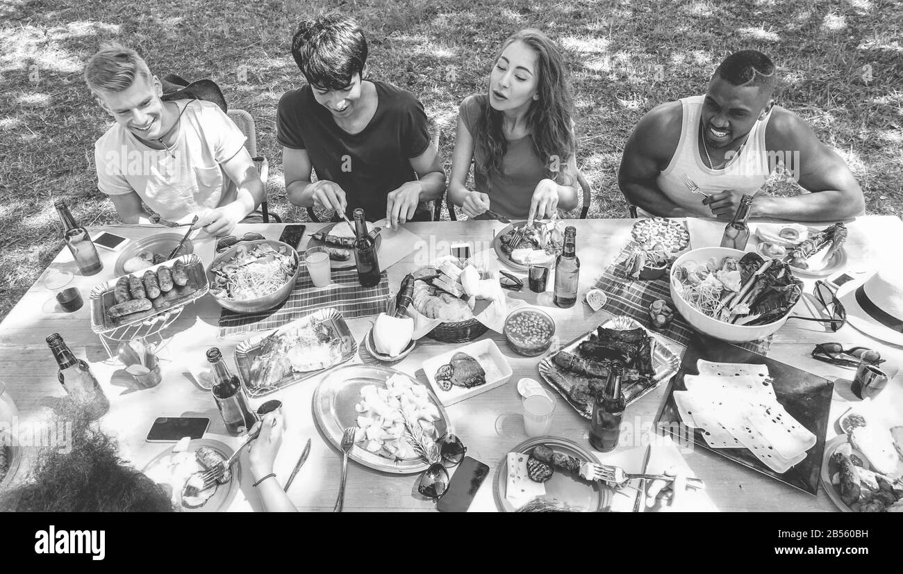 Gruppo di amici felici barbecue il giorno d'estate - giovani che mangiano e bevono birra al barbecue pasto - Focus on center ragazzi - stile di vita giovanile, par Foto Stock
