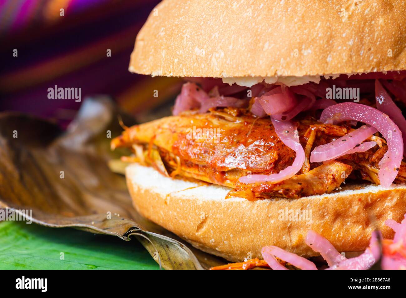 Panino di Cochinita Pibil, servito con cipolle decapate Yucatecan e salsa habanero. Panino di maiale arrosto lento Foto Stock