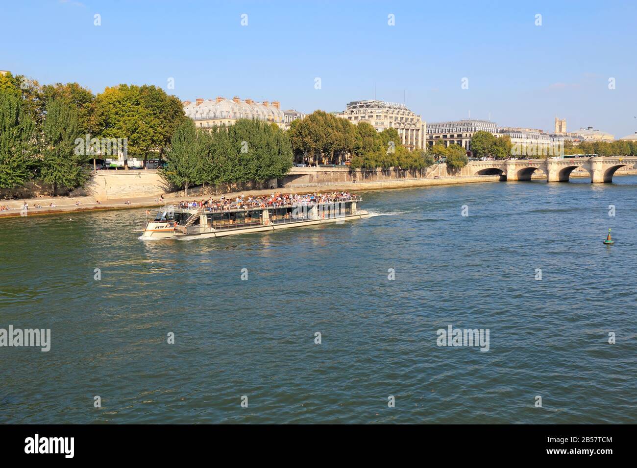 Barca turistica sul fiume Senna vicino alla riva destra, Pont Neuf e l'Ile de la Cite. Queste barche sono popolari con i turisti. Foto Stock