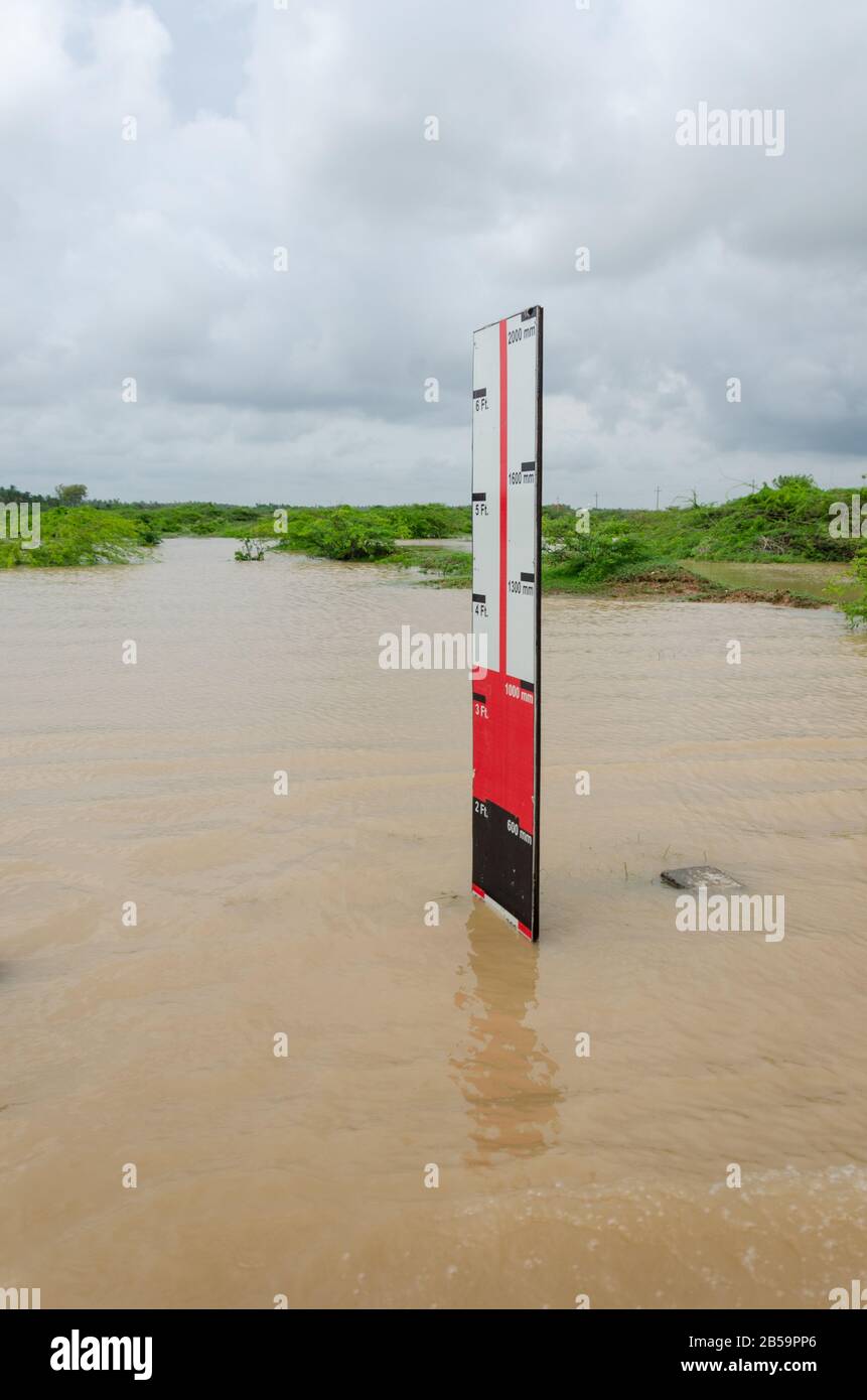 Indicatore del livello dell'acqua stradale che segna la profondità dell'acqua di inondazione durante le piogge pesanti a Mandvi, Hutch, Gujarat, India Foto Stock