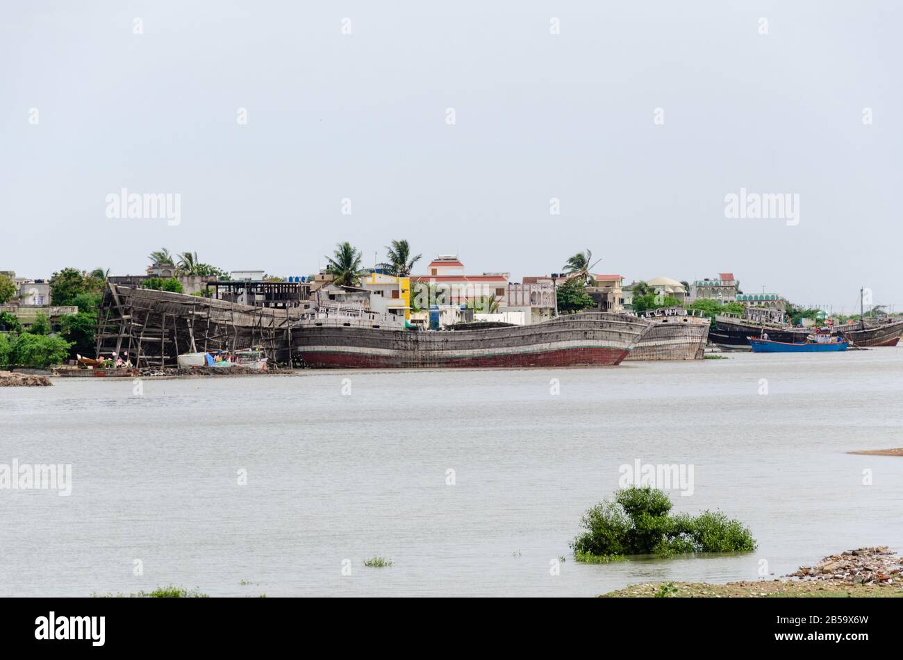 Vista del fiume Rukmavati con le barche e le navi staioned ai porti per la riparazione a Mandvi, Hutch, Gujarat, India. Foto Stock