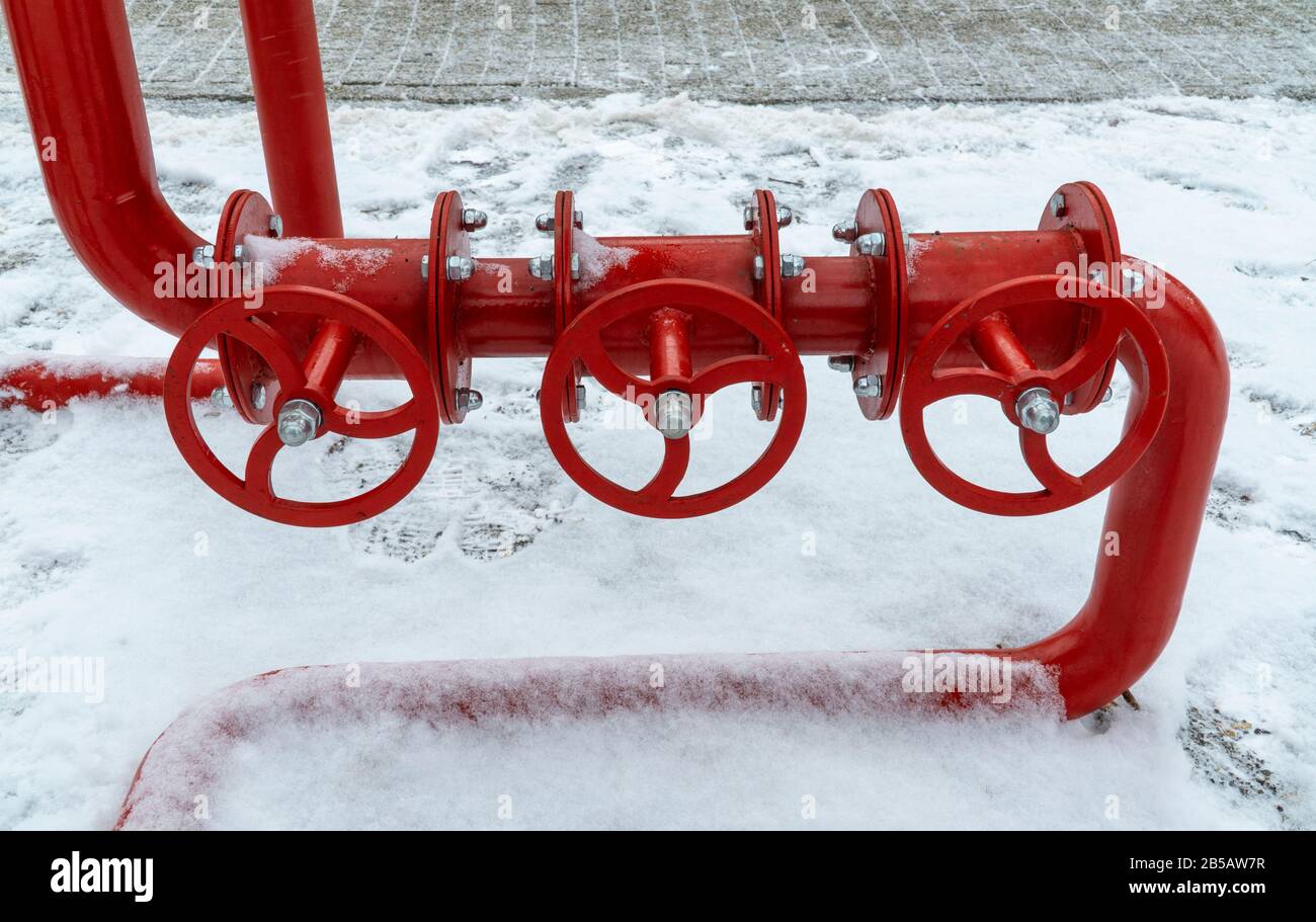 rubinetto d'acqua rosso sulla strada in inverno nella neve. Impianto antincendio ad acqua. Sicurezza antincendio. Foto Stock