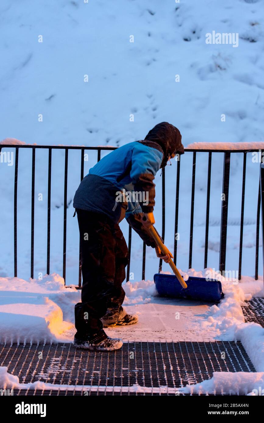 L'uomo rimuove la neve con una pala in una giornata invernale ad Andorra. Foto Stock