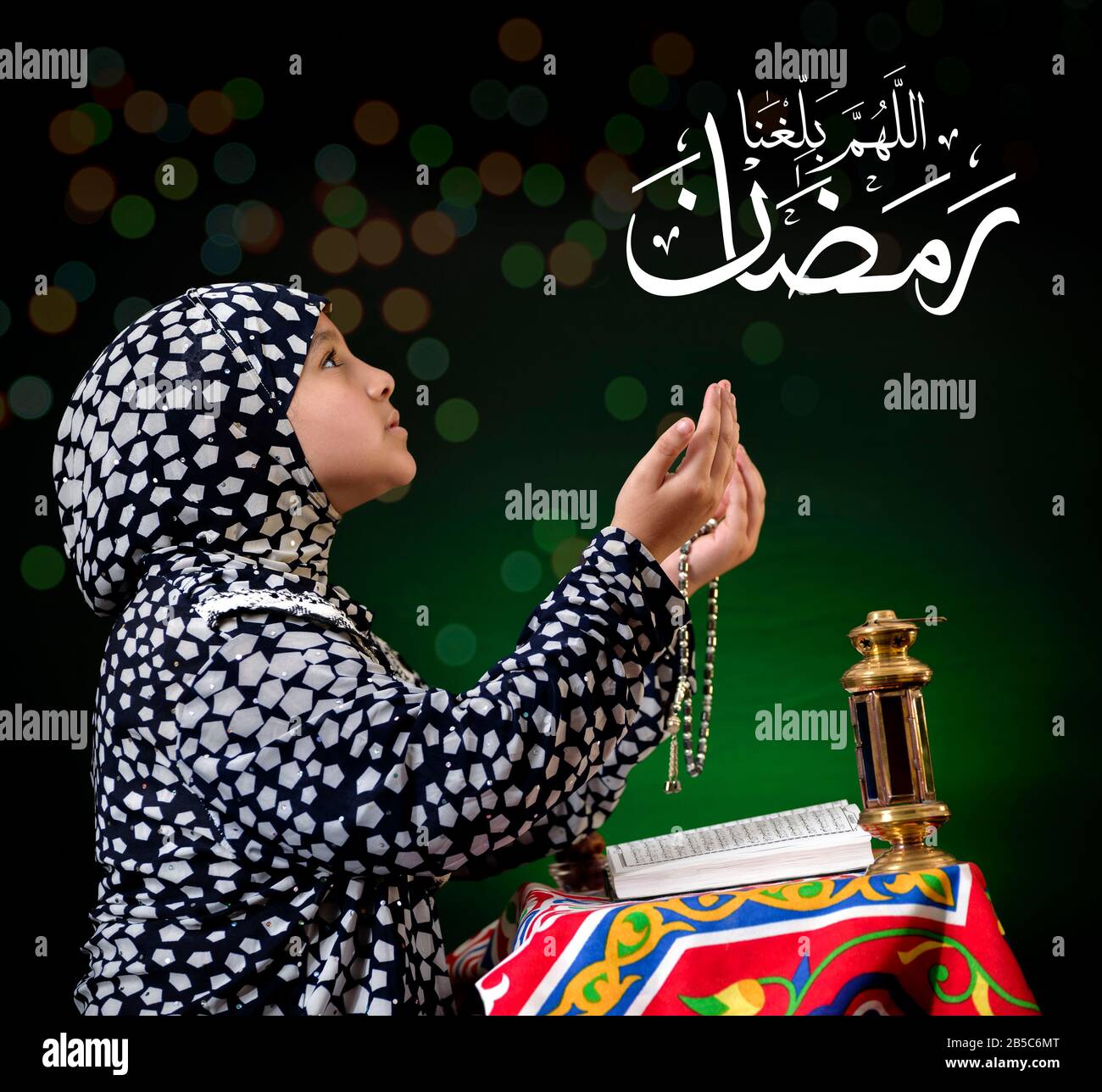 Mani su giovane ragazza musulmana Che Prega per Dio, con il testo arabo di Calligraphy Che Dice 'Dio, aiutaci a raggiungere Ramadan' Foto Stock
