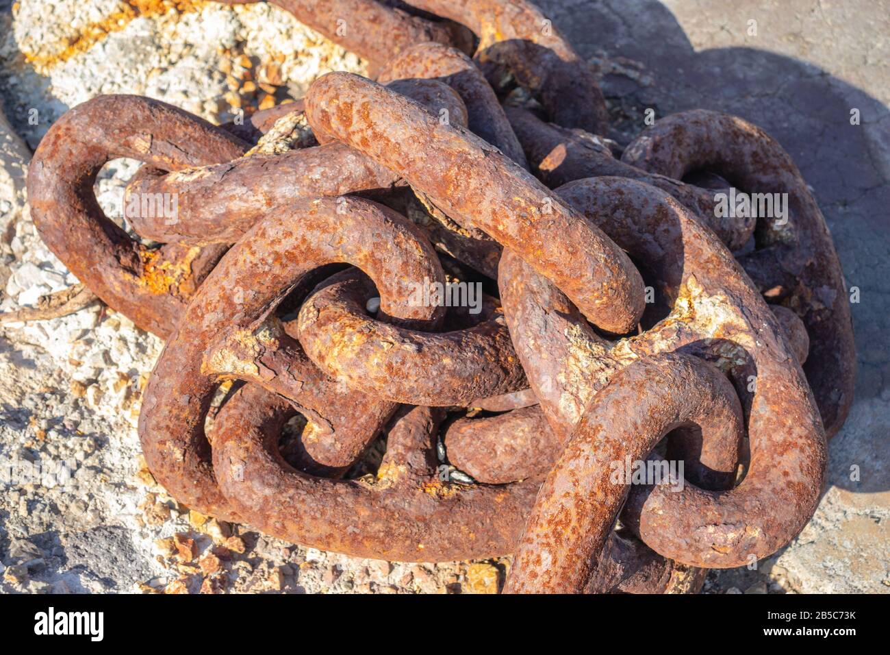 Vecchia catena arrugginita in acciaio sul porto in una giornata di sole Foto Stock