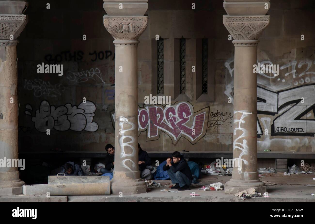 Belgrado, Serbia - 17 ottobre 2019 : Gruppo di giovani rifugiati maschi che si svegliano in un rifugio sporco sotto il ponte del centro città Foto Stock