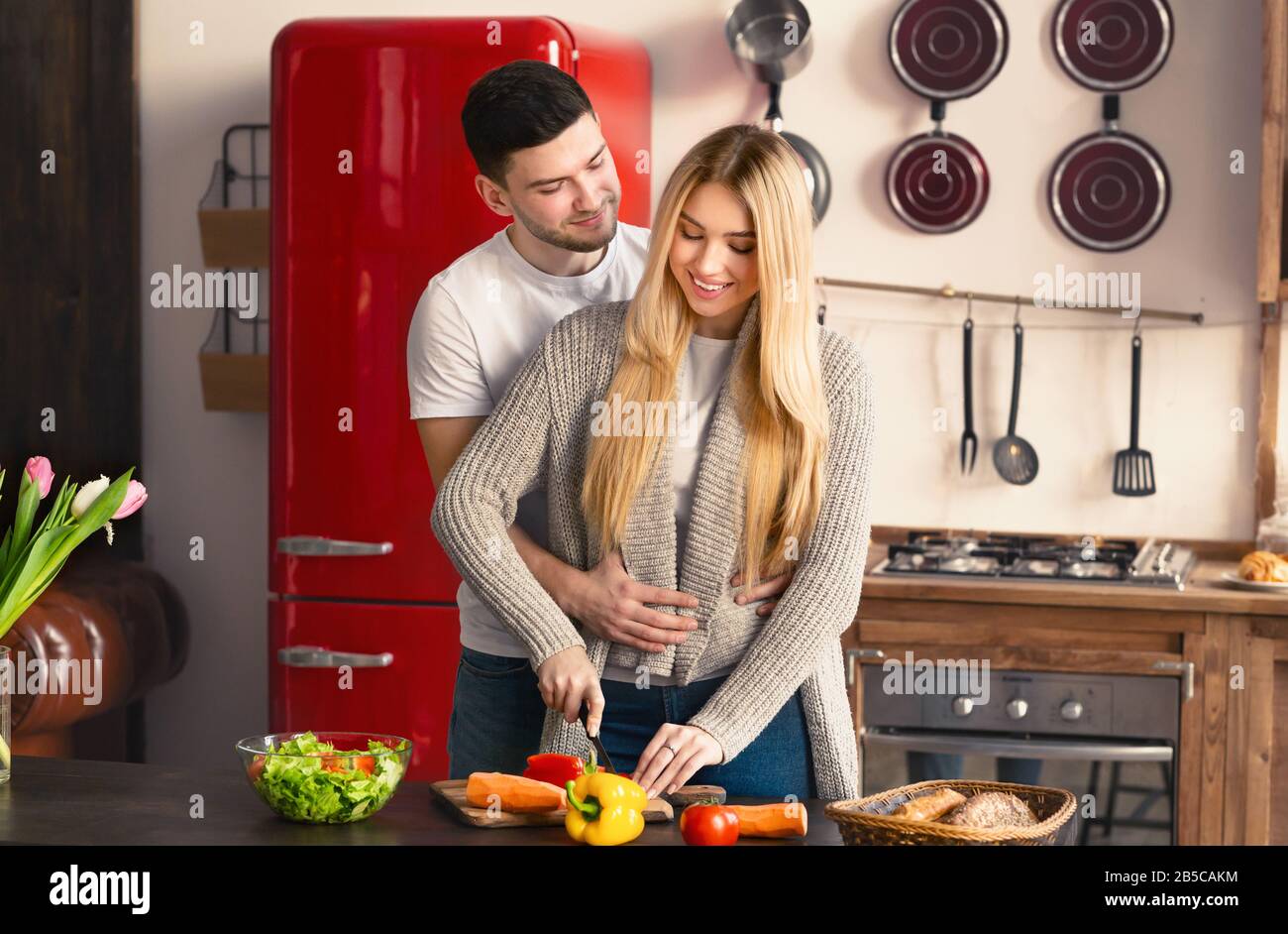 Felice giovane coppia che cucina pasto sano insieme in cucina Foto Stock