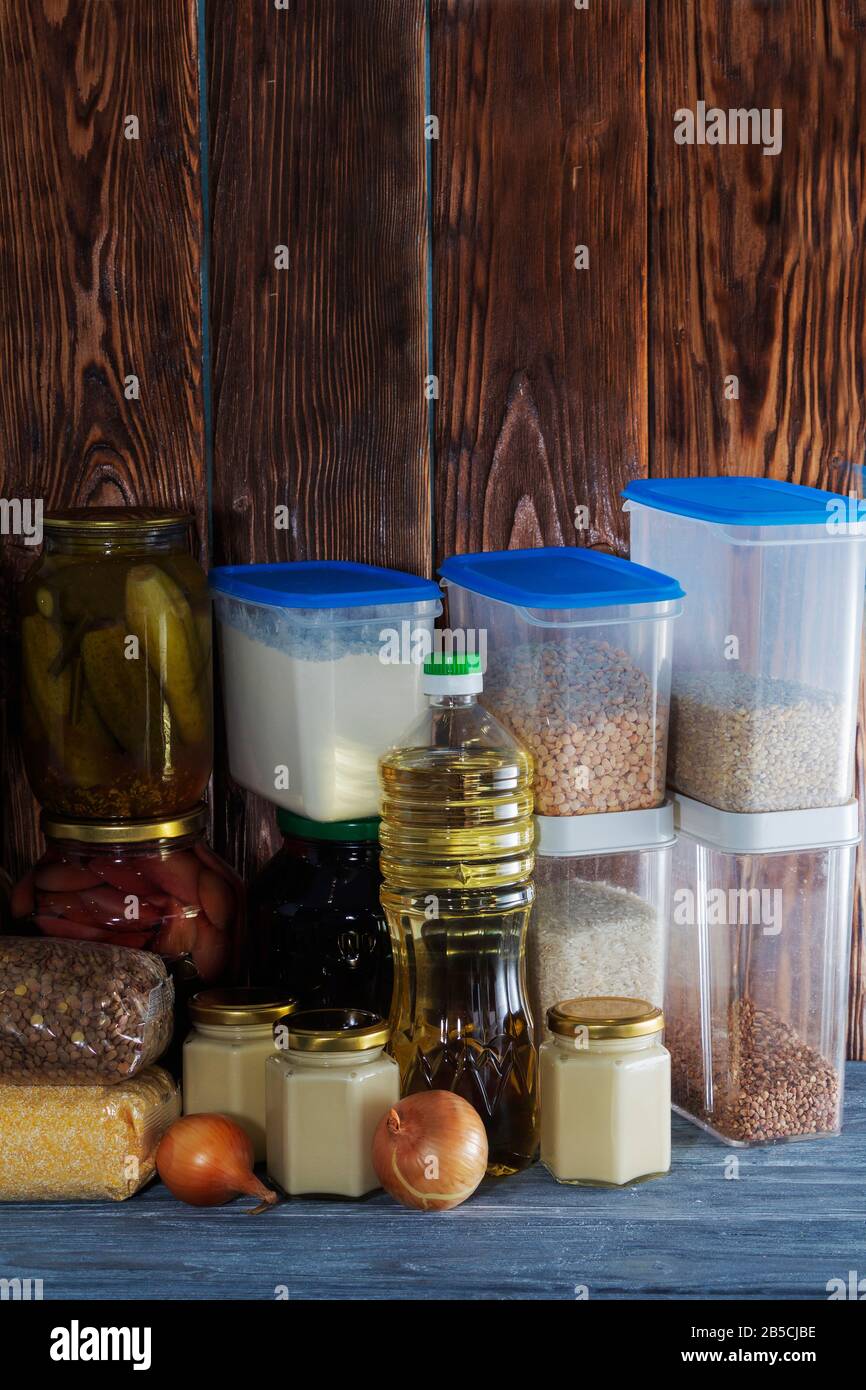 un sacco di vasi di vetro con cibo in scatola e cereali su un ripiano di legno. Foto Stock