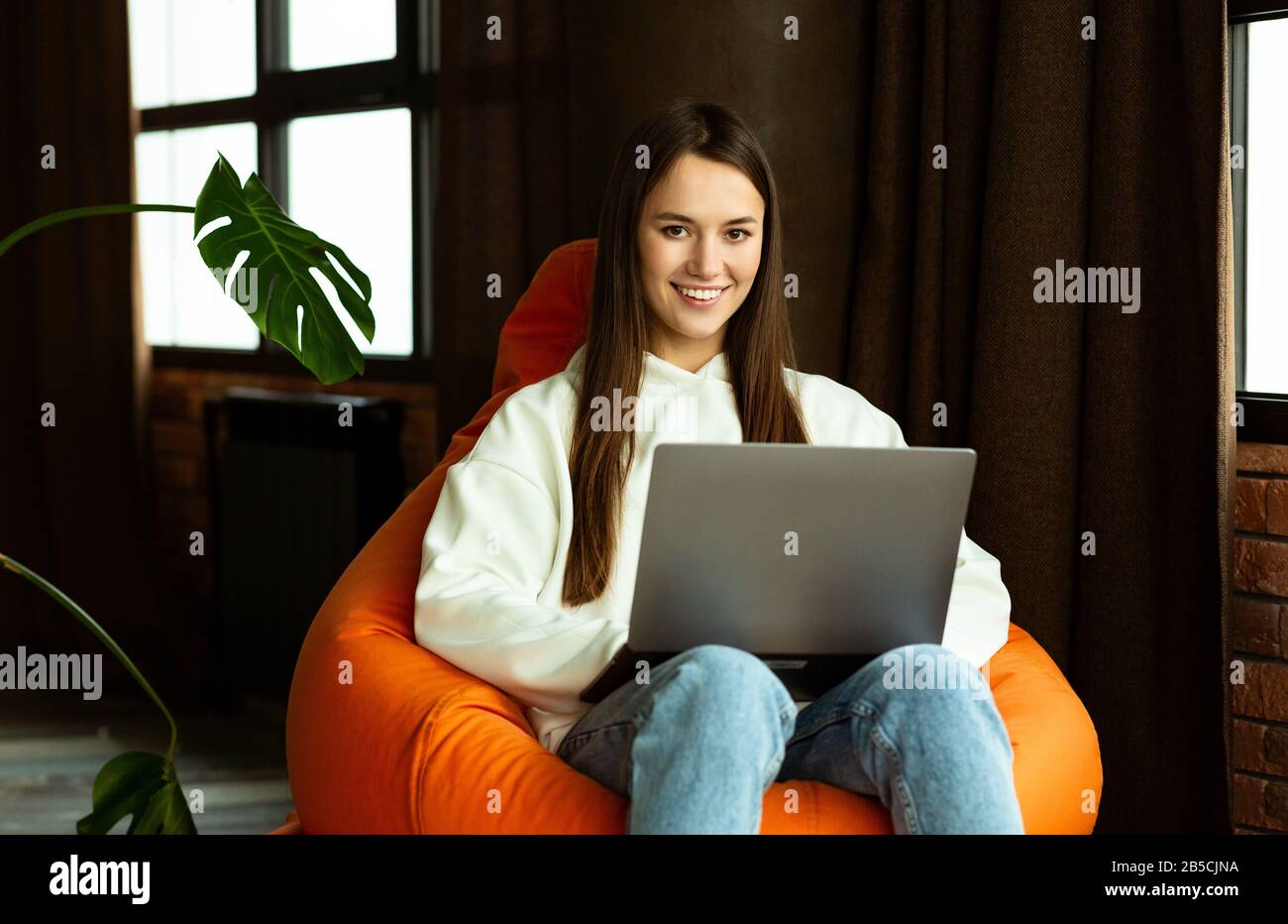 Donna freelance lavora in borsa sedia a casa Foto Stock