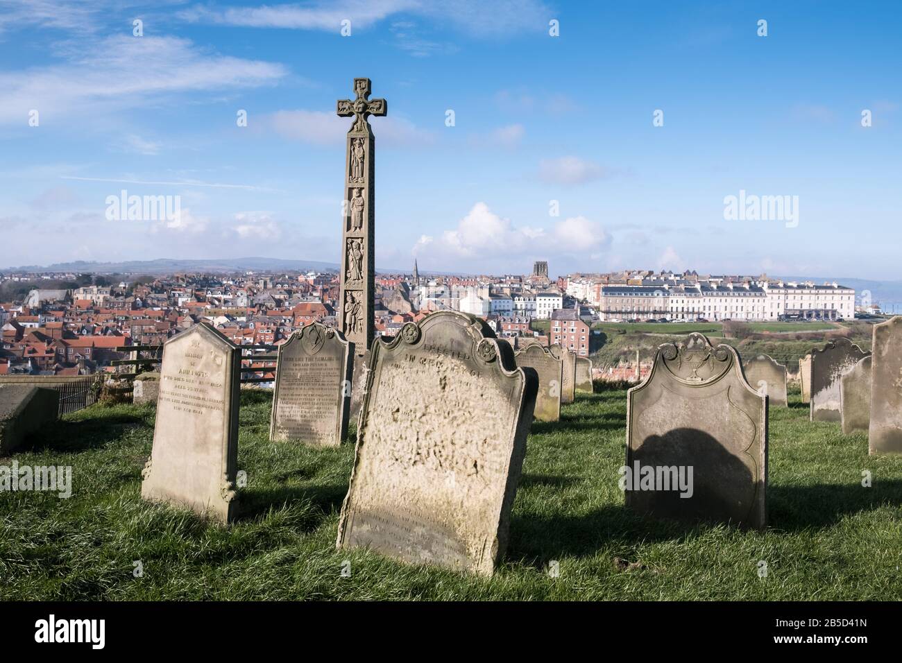 Ammira il cimitero di St Mary verso la città costiera di Whitby, con la Caedmon Cross, la costa del North Yorkshire, Inghilterra, Regno Unito Foto Stock