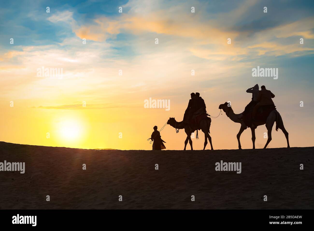 Turista sul cammello indietro nella silhouette al tramonto a Thar deser Jaisalmer Rajasthan, India Foto Stock