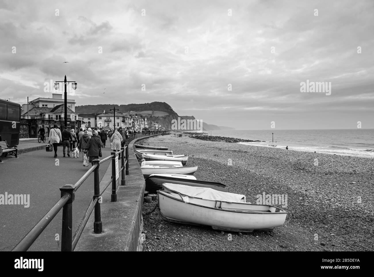 I Daytrippers sono lasciati sul lungomare di Sidmouth per una visita fuori stagione. In lontananza la collina di Seaton e Jurassic Coast è in vista Foto Stock