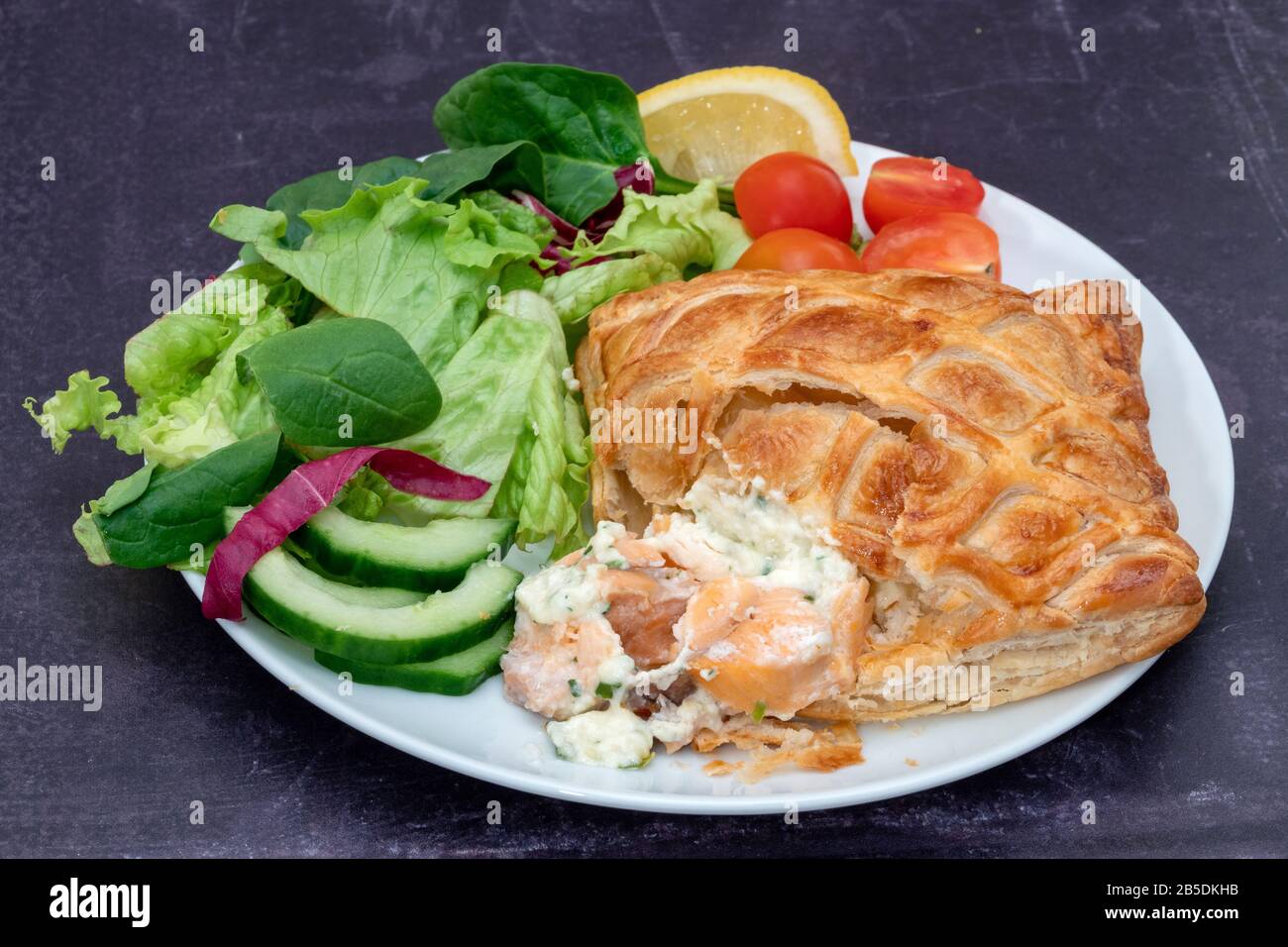Pacco pasticceria di salmone en-croute con insalata Foto Stock