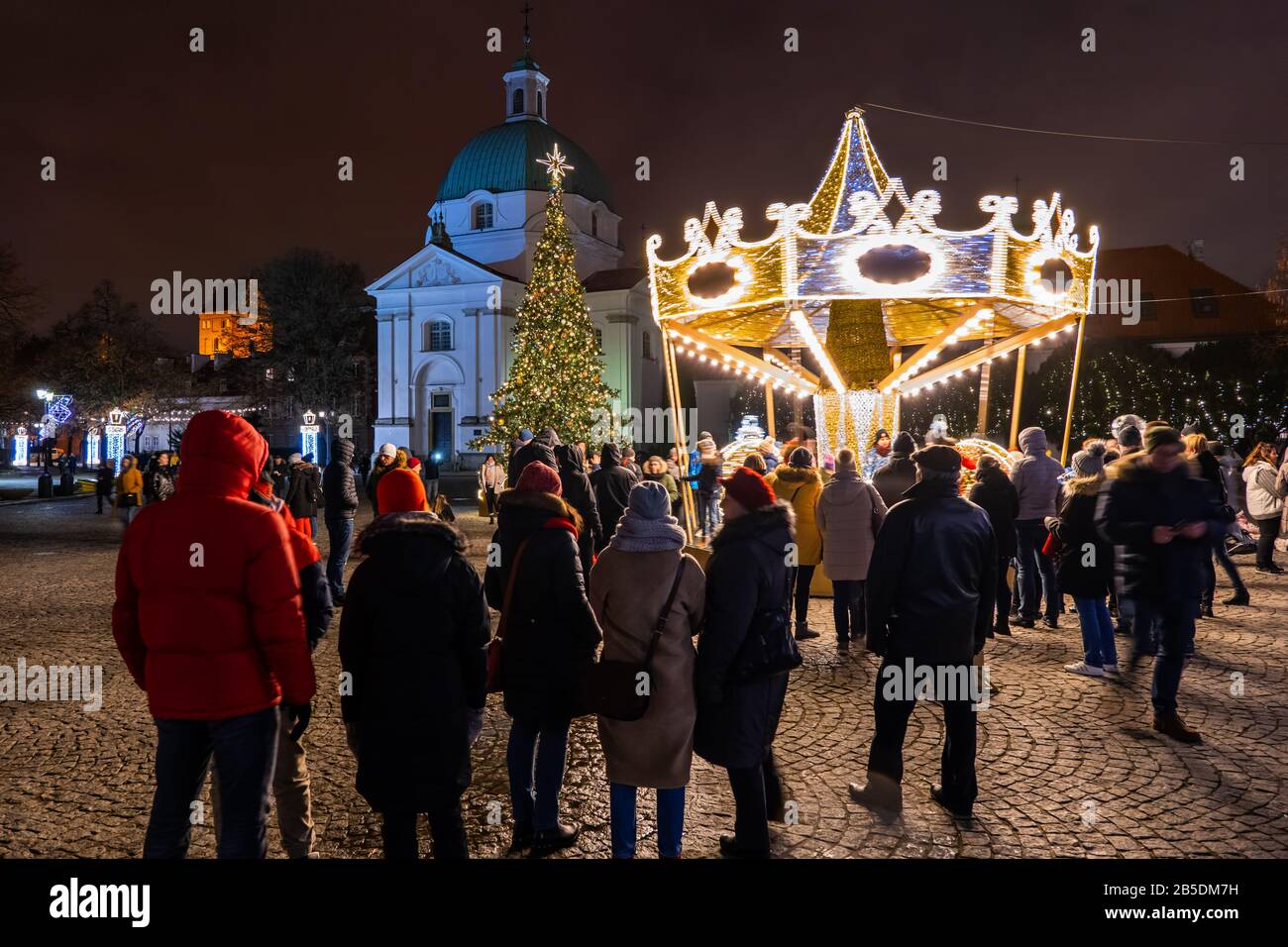 Città di Varsavia in Polonia, persone sulla Piazza del mercato di New Town con giostra rotonda di notte durante la stagione delle vacanze di Natale Foto Stock