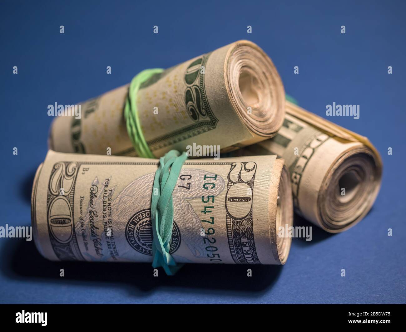 Rotoli delle fatture americane del dollaro sullo sfondo blu Foto Stock
