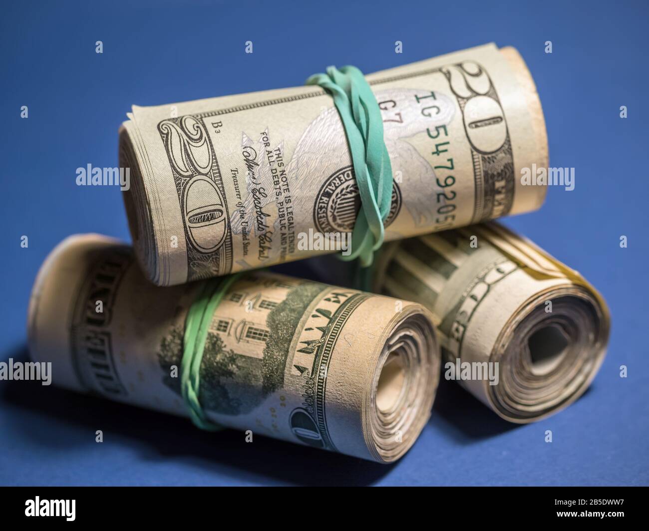 Rotoli delle fatture americane del dollaro sullo sfondo blu Foto Stock