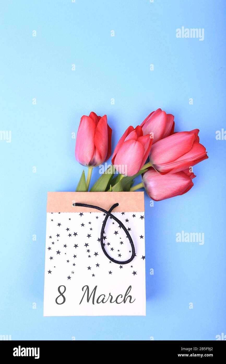 Mazzo di fiori di tulipano primaverile in sacchetto di carta su sfondo blu. Sfondo del giorno di Pasqua. 8 Marzo, Giornata Internazionale Delle Donne, Compleanno, San Valentino O M. Foto Stock