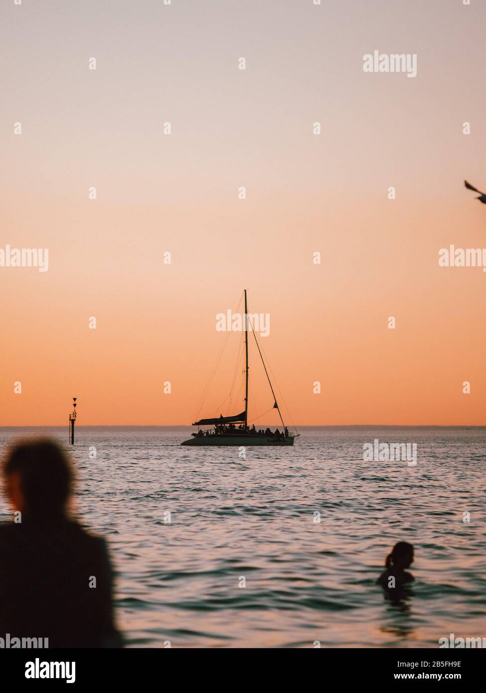La silhouette di una barca a vela nel mare in Australia al tramonto Foto Stock