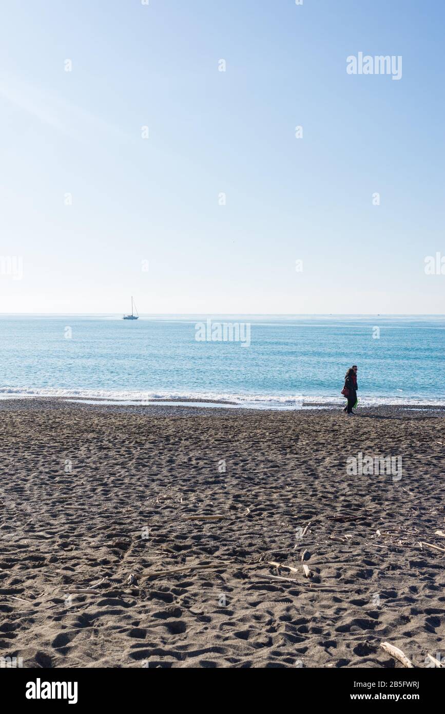 Cecina, Toscana, Italia - Gennaio 2020: Scenario invernale sul mare in Toscana con persone che godono del sole meteo italiano su una spiaggia di sabbia Foto Stock