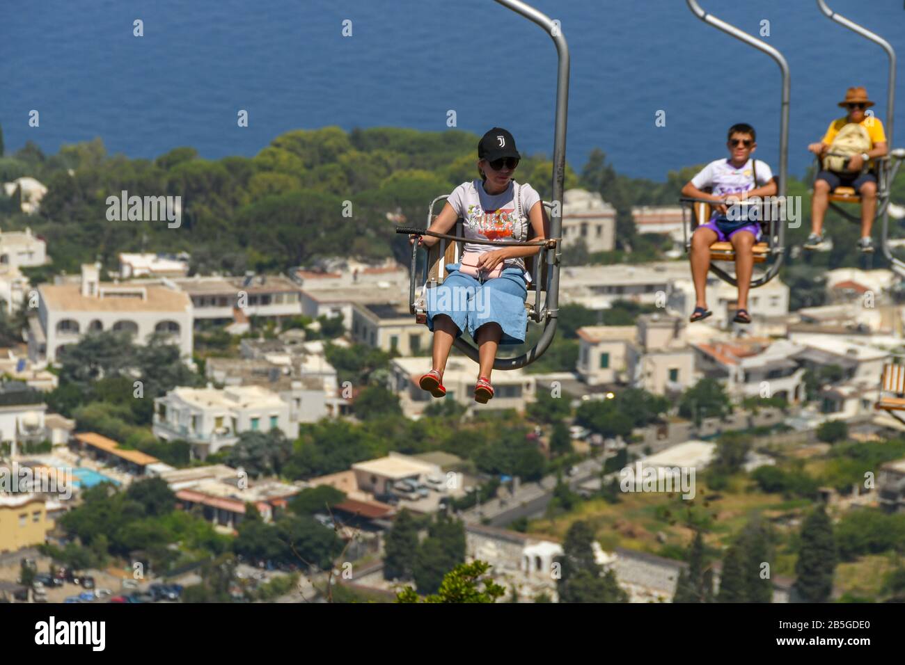 Anacapri, ISOLA DI CAPRI, ITALIA - AGOSTO 2019: Visitatori su una seggiovia che salgono sulla montagna fino alla cima del Monte Solaro sopra Anacapri Foto Stock