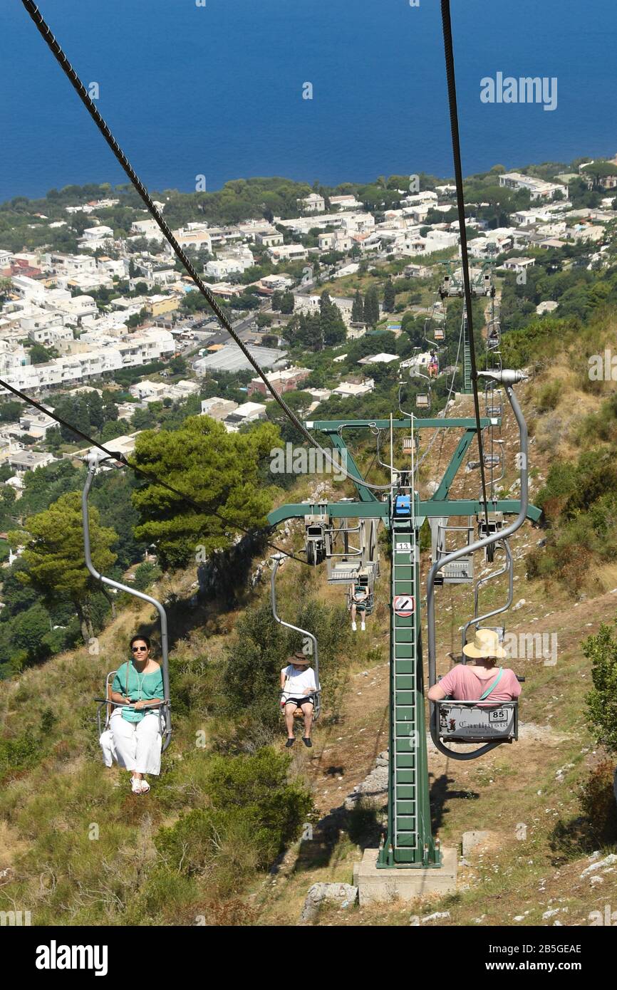 Anacapri, ISOLA DI CAPRI, ITALIA - AGOSTO 2019: Visitatori su una seggiovia che si sposta verso la cima del Monte Solaro sopra Anacapri Foto Stock