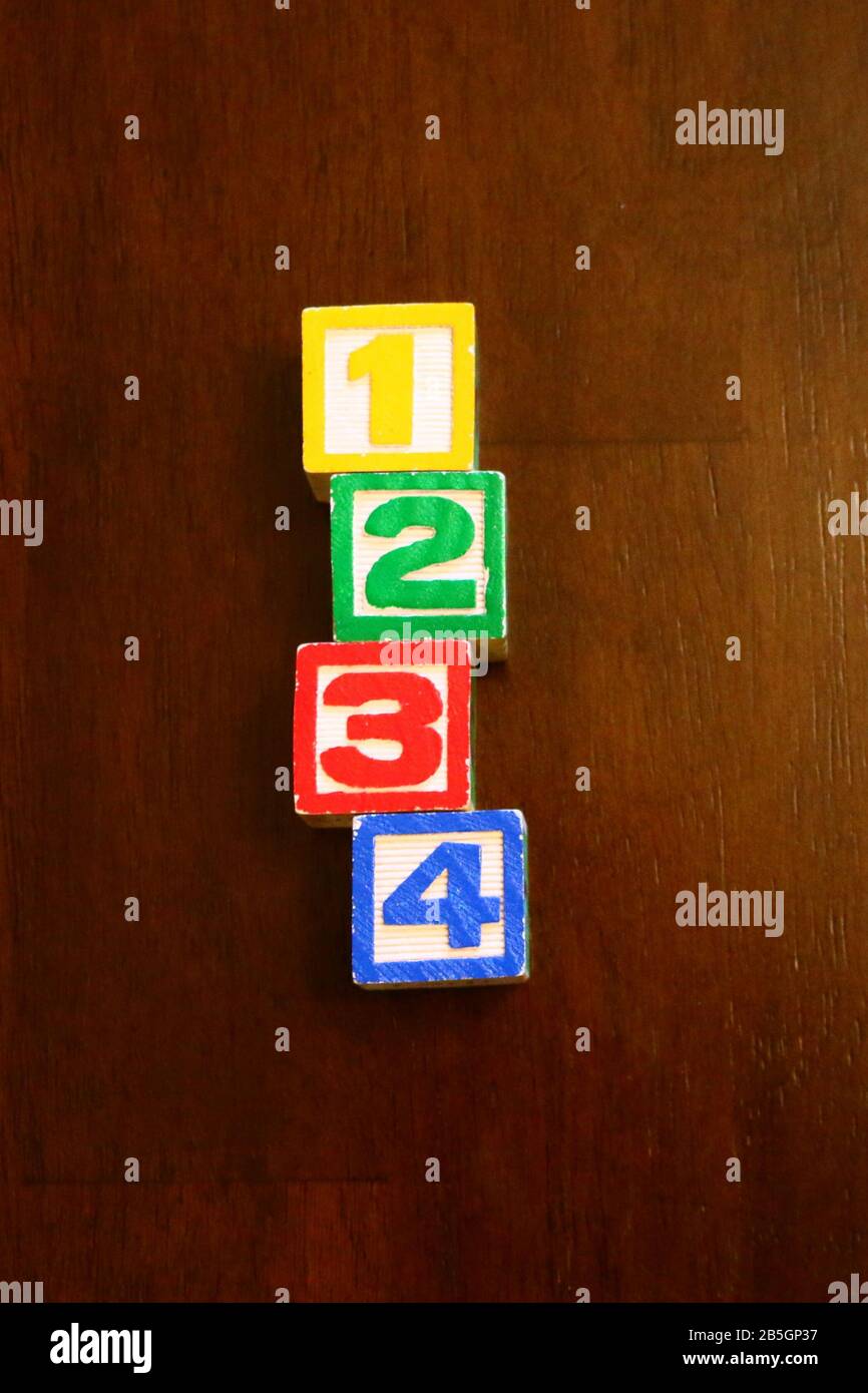 Pila di blocchi di giocattoli in legno alfabeto colorato sullo sfondo Foto Stock