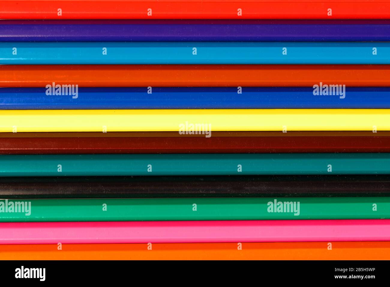 Aste di matite colorate in una riga come sfondo nell'intero schermo. Sfondo texture Foto Stock