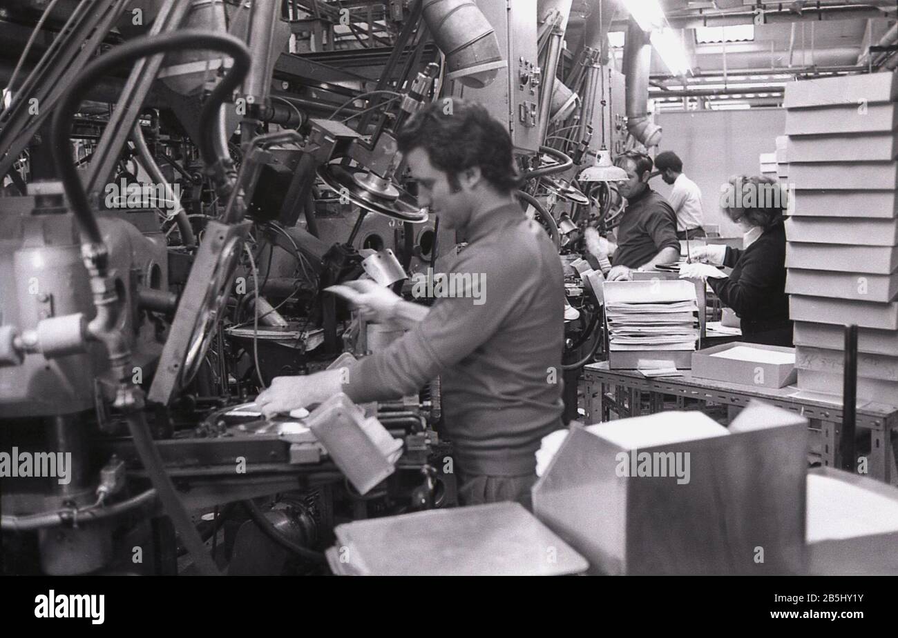 Anni '1970, storico, all'interno di una fabbrica di produzione record, lavoratori maschi che utilizzano attrezzature per la stampa di dischi in vinile, USA. Foto Stock