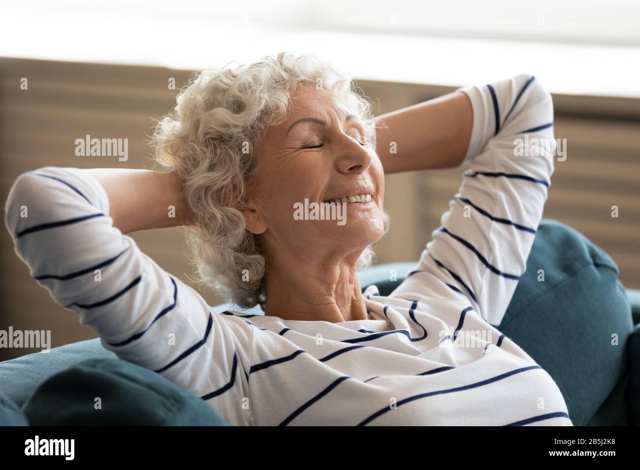 Felice anziana donna rilassarsi dormire su un comodo divano Foto Stock