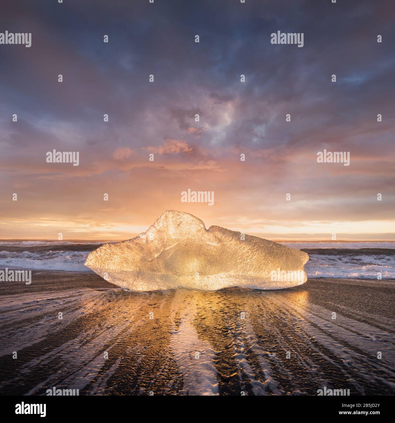 Bellissimo tramonto sulla famosa spiaggia di Diamond, Islanda. Questa spiaggia di lava di sabbia è piena di molte gemme di ghiaccio giganti, situato vicino alla laguna glaciale Jokulsarlon Ice Foto Stock