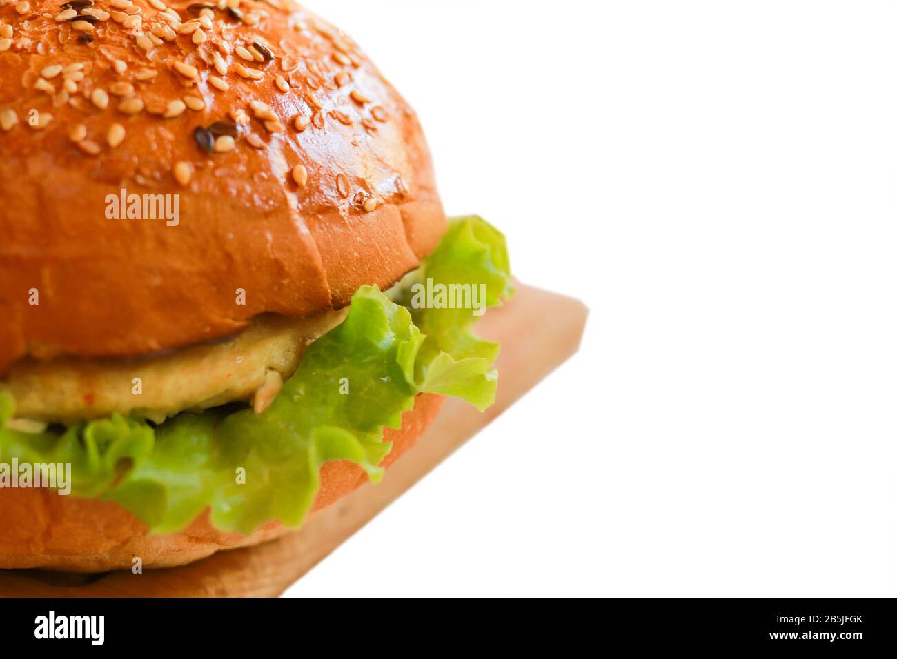 Primo piano hamburger vegetariano Isolato su sfondo bianco con semi di sesamo, carne artificiale, lattuga verde. Messa a fuoco selezionata Foto Stock