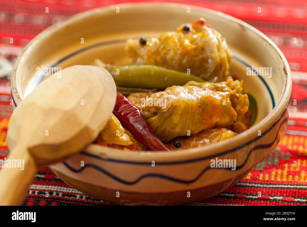 involtini di carne sarmale in ciotola di creta con cucchiaio di legno Foto Stock