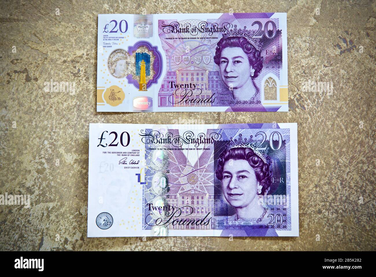 La nuova banconota in polimero £20 e la banconota in carta di cotone £20 su fondo oro Foto Stock