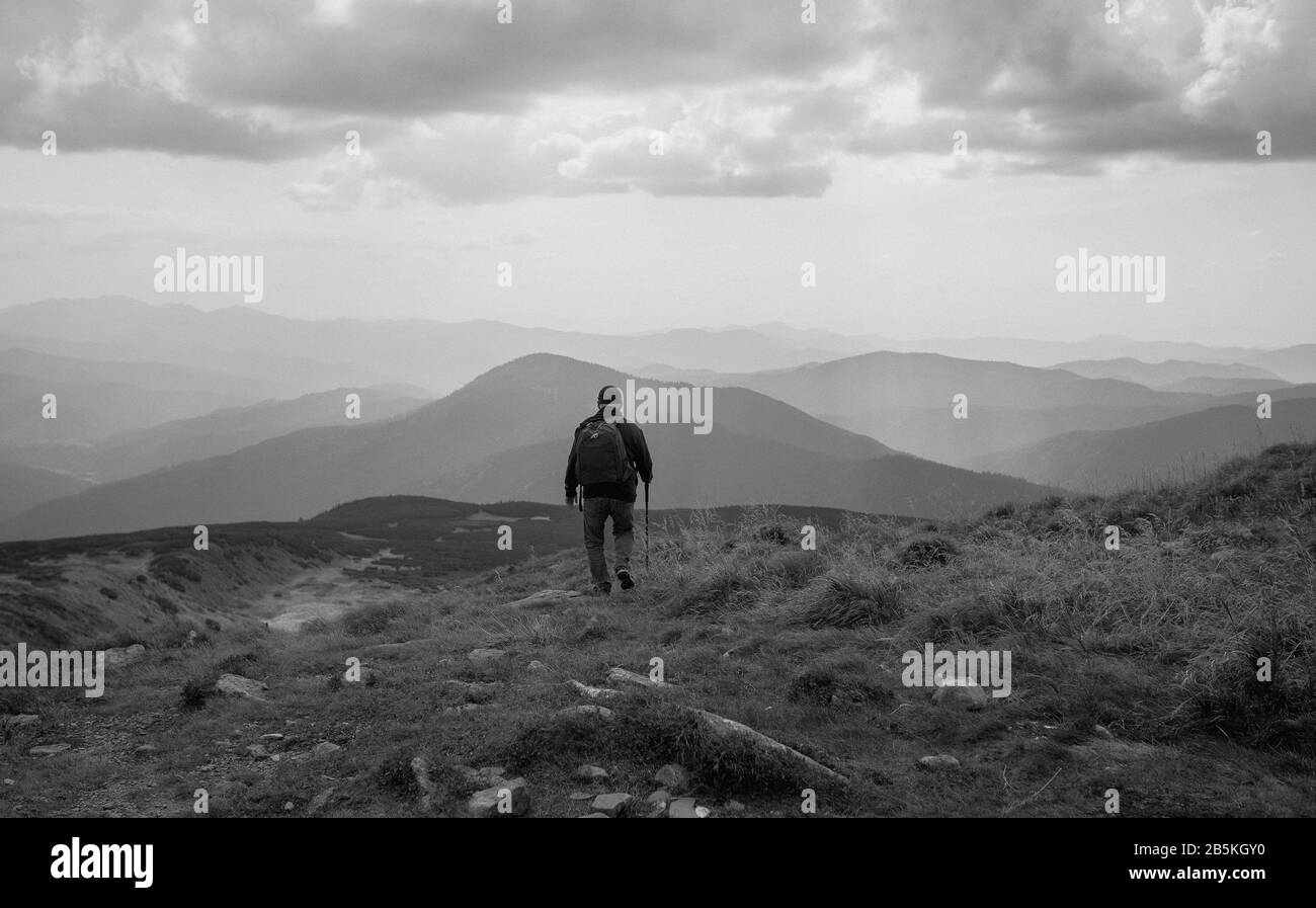 Monocromia Vista dell'uomo che cammina avanti sulle montagne dei Carpazi, in Ucraina. Viaggi, turismo, volontà e natura Foto Stock