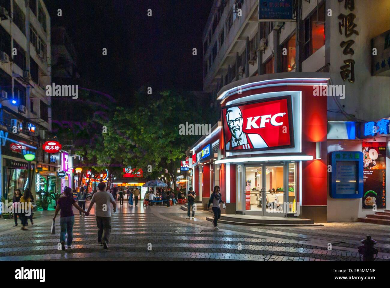 Guilin, Cina - 9 maggio 2010: Zhengyang strada pedonale dello shopping. Luce al neon bianca sul nome rosso del ristorante KFC all'angolo. Ampia vista sulla strada con Foto Stock